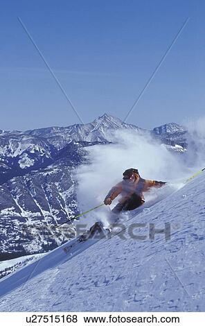 Stock Photo - Young man skiing at high speed on ungroomed slope near Fortress Mountain, Alberta, Canada.. Fotosearch