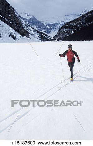 Stock Image - Young woman cross country skiing on Lake Louise, Banff National Park, Alberta, Canada. Fotosearch