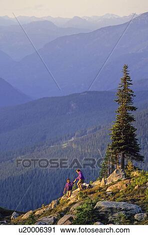 Couple hiking on Whistler Mountain, with coast mtn range in back View Large Photo Image Stock Image - Couple hiking on Whistler Mountain, with coast mtn range in back. Fotosearch