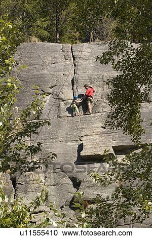Mid-aged man helping daughter tie climbing rope at base of cliff, near Rexford, Montana, USA View Large Photo Image Stock Image - Mid-aged man helping daughter tie climbing rope at base of cliff, near Rexford, Montana, USA. Fotosearch