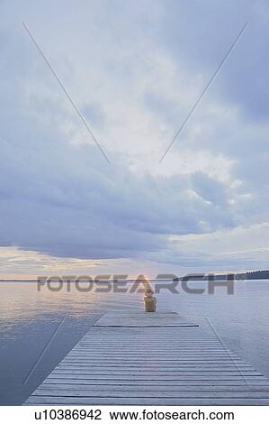 Woman sitting on dock at sun set Clear Lake; Canada, Manitoba, Riding Mountain National Park View Large Photo Image Stock Image - Woman sitting on dock at sun set Clear Lake; Canada, Manitoba, Riding Mountain National Park. Fotosearch