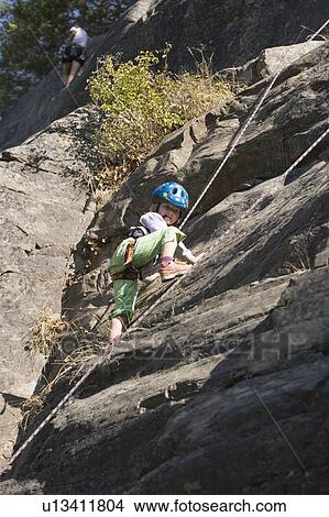 Picture - Young girl (age 5) climbing on granite cliff at Stone Hills near Rexford, Montana, USA. Fotosearch