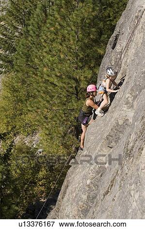 Young woman climbing with daughter (age 7) up granite cliff at Stone Hills near Rexford, Montana, USA View Large Photo Image Stock Photo - Young woman climbing with daughter (age 7) up granite cliff at Stone Hills near Rexford, Montana, USA. Fotosearch