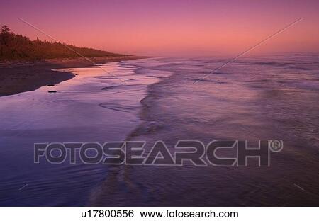 Stock Photograph - Waves approach the beach at sunset, Long Beach, Pacific Rim National Park Reserve, Tofino, BC, Canada. Fotosearch