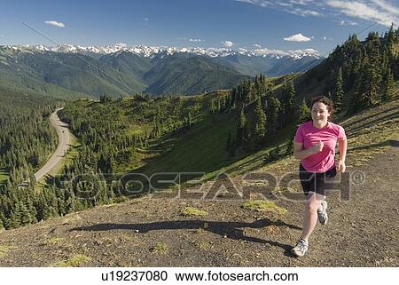 Stock Image - A woman trail running on Hurricane Ridge, Olympic National Park. Fotosearch