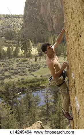 Picture - Man (25-30) clipping in to an anchor while rock climbing, Smith Rock State Park, Terrebonne, Oregon, USA. Fotosearch