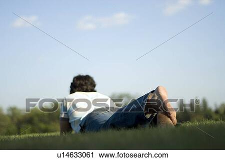 Man lying on grass with feet toward camera, Assiniboine Park, Winnipeg, Canada View Large Photo Image Stock Image - Man lying on grass with feet toward camera, Assiniboine Park, Winnipeg, Canada. Fotosearch