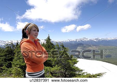 Stock Image - Teen girl looking over mountains, Vancouver Island, Canada. Fotosearch