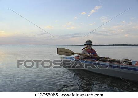 Stock Photography - Woman in kayak Clear Lake Riding Mt. Nat. Park; Canada, Manitoba, Riding Mountain National Park. Fotosearch