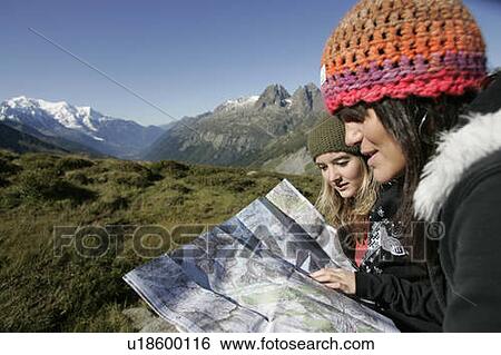 Stock Photograph - Young girls (19) reading a map in front of Mont Blanc, Col de Balme Chamonix, France. Fotosearch