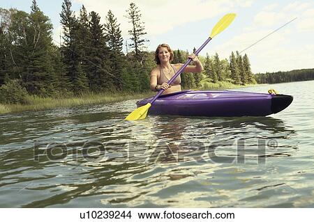 Picture - Young woman paddling kayak, Lake Katherine, Riding Mountain National Park, Manitoba, Canada. Fotosearch