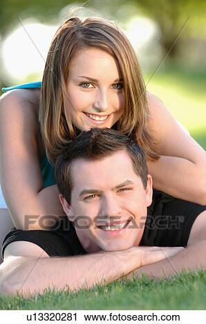 Stock Image - Boy and girl teenagers in grass at park, Regina, Saskatchewan. Fotosearch