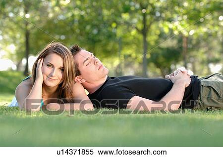 Stock Photography - Boy and girl teenagers in grass at park, Regina, Saskatchewan. Fotosearch