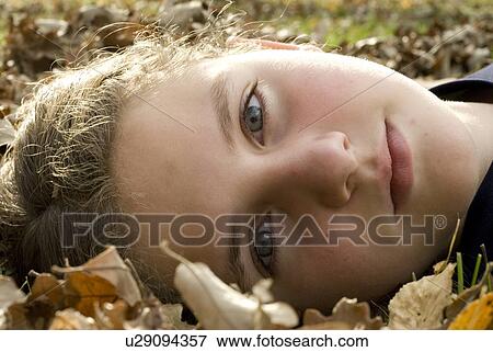 Stock Photo - Girl lying in the leaves, Winnipeg, Canada. Fotosearch