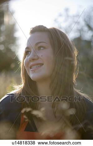Stock Photo - Portrait of female, 17, in tall grass, Vancouver, BC. Fotosearch
