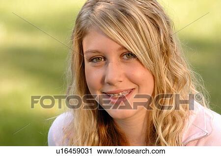 Stock Image - Portrait of young blonde girl on grass, Regina, Saskatchewan. Fotosearch