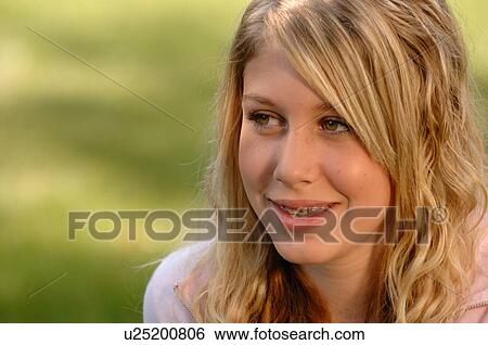 Stock Photograph - Portrait of young blonde girl on grass, Regina, Saskatchewan. Fotosearch