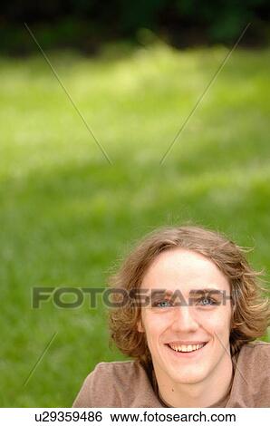 Stock Photograph - Portrait of young man in park, Regina, Saskatchewan. Fotosearch
