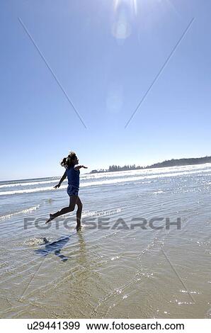 Pre-teen girl running on beach, Vancouver Island, B. C. View Large Photo Image Stock Photo - Pre-teen girl running on beach, Vancouver Island, B. C.. Fotosearch