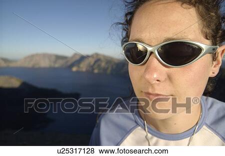 Woman (20-25) with sunglasses in front of lake and mountains, Crater Lake National Park, Oregon View Large Photo Image Stock Photo - Woman (20-25) with sunglasses in front of lake and mountains, Crater Lake National Park, Oregon. Fotosearch