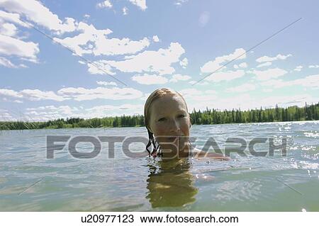 Stock Image - Woman with wet hair in lake, Lake Katherine, Riding Mountain National Park, Manitoba, Canada. Fotosearch