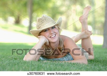 Stock Image - Young blonde female in park with hat, Regina, Saskatchewan. Fotosearch