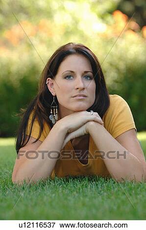 Young woman laying on grass, Regina, Saskatchewan View Large Photo Image Stock Photo - Young woman laying on grass, Regina, Saskatchewan. Fotosearch