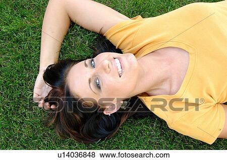 Young woman laying on grass, Regina, Saskatchewan View Large Photo Image Stock Photo - Young woman laying on grass, Regina, Saskatchewan. Fotosearch