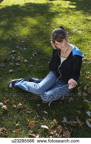 Stock Photograph - Young woman listening to Ipod outdoors, Brantford, Ontario. Fotosearch