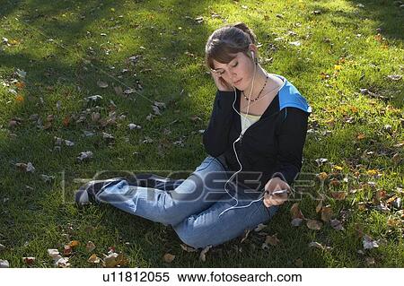 Stock Photography - Young woman listening to Ipod outdoors, Brantford, Ontario. Fotosearch