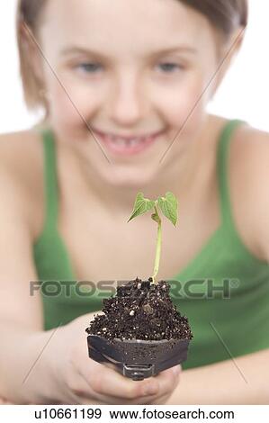 Stock Photo - 9 year old girl with small plant on garden spade. Fotosearch