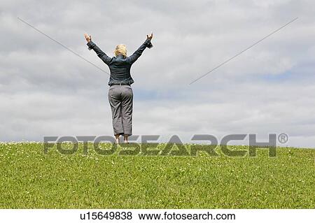 Blonde woman arms raised to sky, top of a hill. View Large Photo Image Stock Photo - Blonde woman arms raised to sky, top of a hill.. Fotosearch