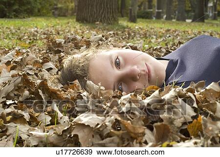 Stock Photo - Girl lying in the leaves, Winnipeg, Canada. Fotosearch