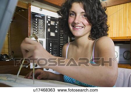 Stock Image - 14 Year Year Old at the Navigation Station of a Sailboat.. Fotosearch