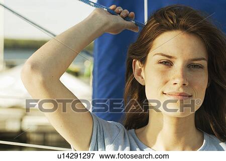 Stock Photo - Portrait of young woman wearing hemp shirt on sailboat, Clear Lake, Riding Mountain National Park, Manitoba, Canada. Fotosearch