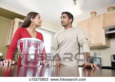Stock Image - Couple beside water filtre jug, avoiding use of bottled water, Winnipeg, Canada, avoiding use of bottled water. Fotosearch
