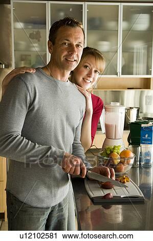 Stock Image - Couple cutting organic fruit for smoothie, Winnipeg, Canada. Fotosearch
