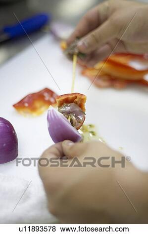 Stock Photo - Detail of hands preparing shish kabobs. Fotosearch