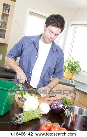 Man in kitchen cutting vegetables beside kitchen compost bin, Winnipeg, Canada View Large Photo Image Stock Image - Man in kitchen cutting vegetables beside kitchen compost bin, Winnipeg, Canada. Fotosearch