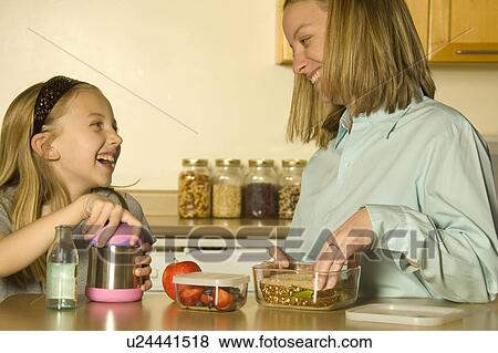 Stock Photo - Mother and daughter preparing a healthy pack lunch. Fotosearch