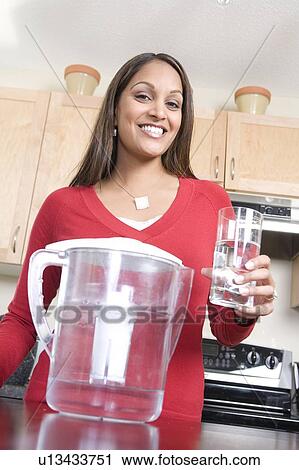 Woman holding glass of water from filtre jug, avoiding use of bottled water, Winnipeg, Canada, avoiding use of bottled water View Large Photo Image Stock Image - Woman holding glass of water from filtre jug, avoiding use of bottled water, Winnipeg, Canada, avoiding use of bottled water. Fotosearch
