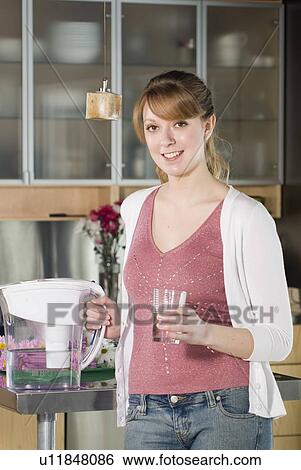 Woman with glass of water from filtred jug View Large Photo Image Stock Photograph - Woman with glass of water from filtred jug. Fotosearch