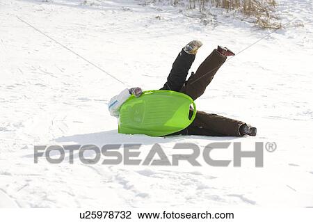 Stock Image - 13 and 9 year olds tip over at bottom of hill, Winnipeg, Canada. Fotosearch