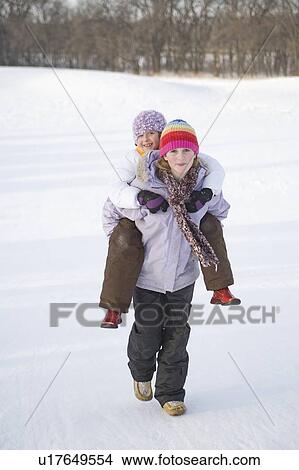 Picture - 13 year old carries 9 year old up hill on back, Winnipeg, Canada. Fotosearch