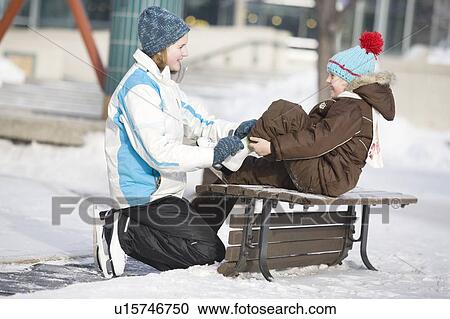 13 year-old girl helps 9 year-old girl tie skates, at The Forks, Winnipeg, Canada View Large Photo Image Stock Image - 13 year-old girl helps 9 year-old girl tie skates, at The Forks, Winnipeg, Canada. Fotosearch