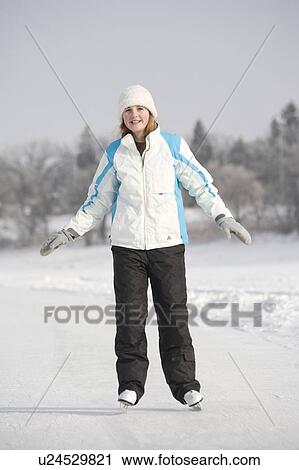 Stock Image - 13 year old girl skating on Red River, Winnipeg, Canada. Fotosearch