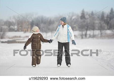 Stock Image - 9 and 13 year-old girls skating on Red River, Winnipeg, Canada. Fotosearch