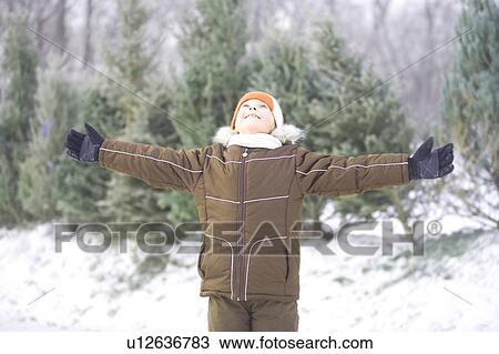 Stock Image - 9-year old girl with arms outstretched looking upward, Winnipeg, Canada. Fotosearch
