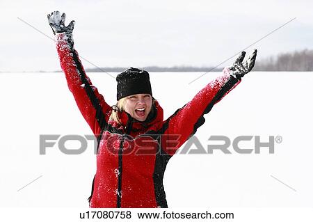 Stock Photo - Blonde woman arms raised, cheerful expression.. Fotosearch
