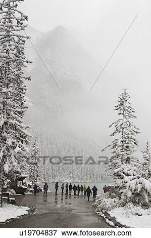Stock Photo - Tourists at Lake Louise, during a snow fall.. Fotosearch